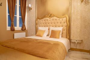 a bedroom with a large bed with a gold headboard at Compact City-Centre Studio with Parking and Wi-Fi in Bordeaux