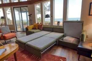 库斯贝#StayinMyDistrict Cape Arago Sanctuary at the Sea的带大沙发和窗户的客厅