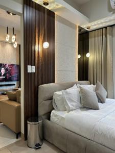 a bedroom with a large bed and a television at Stylish 1BR Near Airport Facing the Bay - 9d in Manila