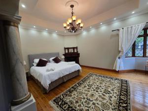 a bedroom with a bed and a chandelier at President's Place in Parys