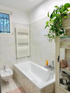a bathroom with a large white tub and a toilet at Un Nido nel Verde in Cervia