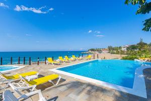 a pool with chairs and the ocean in the background at Los Balcones, Sosua, Ocean Front! in Sosúa