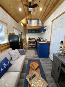 a living room with a couch and a kitchen at Stargazer Tiny Cottage in Shay