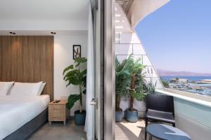 埃拉特Nathan's Suites On The Beach的一间卧室设有一张床和一个植物阳台
