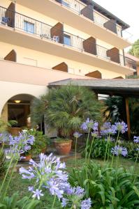 a garden in front of a building with purple flowers at Hotel Villa Adriana in Monterosso al Mare