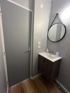 a bathroom with a sink and a mirror at Allium, Appt entièrement rénové avec parking in Courseulles-sur-Mer