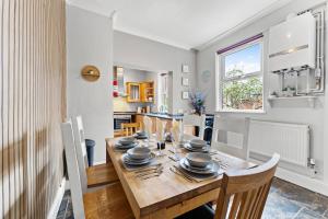 a dining room and kitchen with a wooden table and chairs at Stylish 6-BR home, Monthly Savings, Free Parking in Nether Edge
