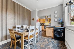 une cuisine et une salle à manger avec une table et un lave-vaisselle dans l'établissement Elegant 6-BR home, Monthly Savings, Free Parking, à Nether Edge