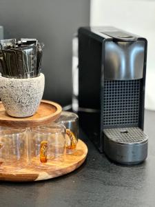 a table with glasses and a microwave and acomputer at Appartement de Charme - Le Large in La Tente-Verte