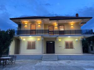 a white house with a balcony and a table at Villa SM Shkodër in Shkodër