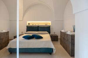 a bedroom with a bed with two blue pillows at Miro Luxury Home in San Vito dei Normanni +44 photos