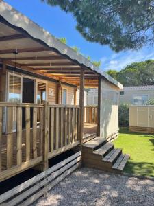 une cabane en bois avec une terrasse et des escaliers dans l'établissement Mobil Home CasaLuca 3 chambres 2 Salles d'eau, à Canet