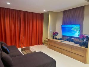a living room with a couch and a flat screen tv at Comfy townhouse at best location in Bangrak Beach
