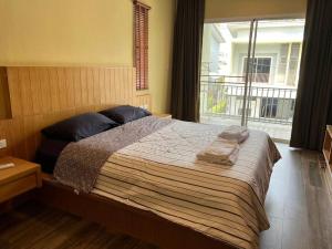 a bedroom with a bed with two pillows and a window at Comfy townhouse at best location in Bangrak Beach