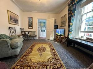 a living room with a couch and a rug at Seaway Beach House Looe Beach in Looe
