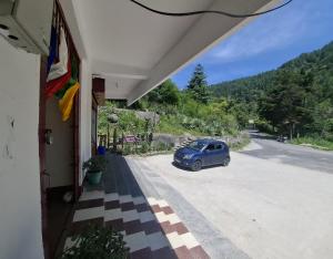 a blue car parked on the side of a road at Tranquil River Nest in Rupa