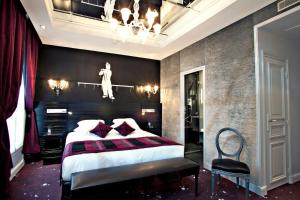 a bedroom with a king sized bed and a chandelier at Maison Albar- Le Champs-Elysées in Paris