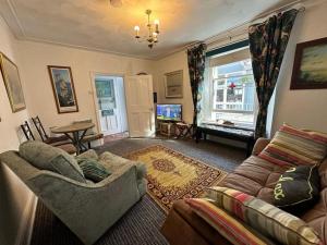 a living room with a couch and a tv at Seaway Beach House Looe Beach in Looe +101 photos