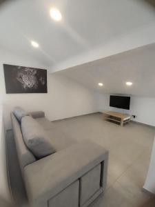 a living room with a couch and a flat screen tv at Casa cascais in São Domingos de Rana +2 photos