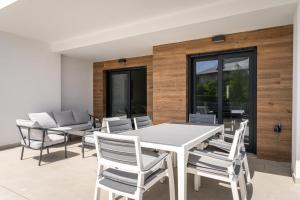 a dining room with a white table and chairs at Luxury Apartment in Mil Palmeras in Dehesa de Campoamor