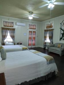 a bedroom with two beds and a couch at The Great House Inn in Belize City