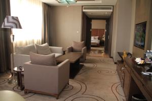 una sala de estar con sofás y sillas en una habitación de hotel en Fleuve Congo Hotel By Blazon Hotels, en Kinshasa