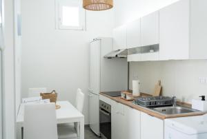 a kitchen with white cabinets and a sink at Appartamento Regina Margherita in Crotone +63 photos