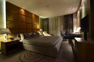 een hotelkamer met een groot bed en een bureau bij Fleuve Congo Hotel By Blazon Hotels in Kinshasa