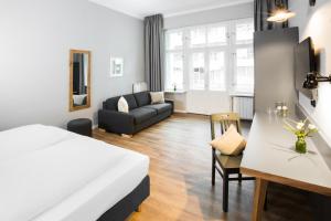 a bedroom and living room with a bed and a couch at Anna 1908 in Berlin