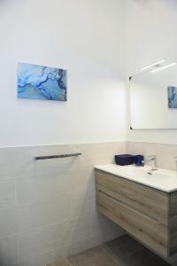 een badkamer met een wastafel en een spiegel bij La Dimora In Blu in Bologna