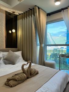 a towel on a bed with a large window at Stylish 1BR Near Airport Facing the Bay - 7b in Manila +31 photos