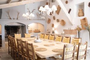 a dining room with a long table and chairs at Domaine de la Lisière in Sault-de-Vaucluse