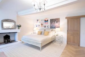 a white bedroom with a bed and a fireplace at Domaine de la Lisière in Sault-de-Vaucluse +27 photos