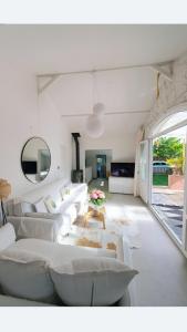 a living room with white couches and a table at Bord de rivière chez Anne in Sainte-Gemme-Moronval