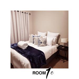 una camera da letto con letto, cuscini e tende di The Cottage a Cradock