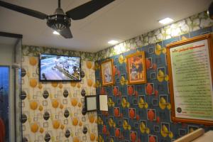 a room with a tv on a wall at Lemuna Hotel & Restaurant in Swat