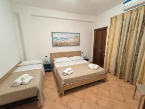 a bedroom with two beds with towels on them at Le perle 2 di Naxos in Giardini Naxos