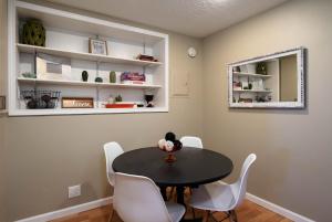 a dining room with a black table and white chairs at #StayinMyDistrict St Johns Forest Park Apt in Portland
