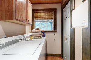 a kitchen with a white sink and a window at Driftwood Hideaway in Canyon Lake