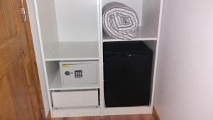 un piccolo mobile bianco con un forno a microonde e un frigorifero di Travelers by Rio NaturAL a Vila Nova de Milfontes