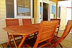 una mesa de madera y sillas en un porche en Mobile Homes Peroš, en Zaton