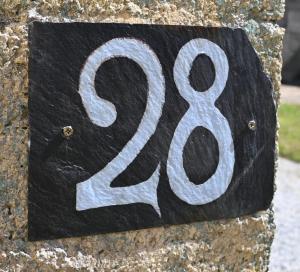 un cartello su una roccia con il numero otto di Keriven Cottage a Keriven