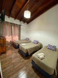 a room with two beds and a desk in it at Orquídeas De La Selva in Puerto Iguazú