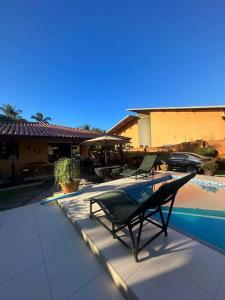 eine schwarze Bank neben einem Swimmingpool in der Unterkunft Experiência surreal em Àguas de Olivença, Ilhéus BA in Olivença + 26 Fotos
