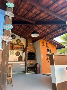 eine Terrasse mit einem gemauerten Kamin und einer Holzdecke in der Unterkunft Experiência surreal em Àguas de Olivença, Ilhéus BA in Olivença