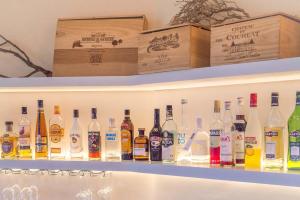 a shelf filled with lots of bottles of alcohol at Armonia Bay Hotel in Kokkari