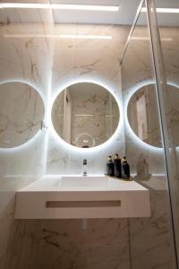 a bathroom with a sink and two mirrors at Pries Homes - Center Beach in Málaga