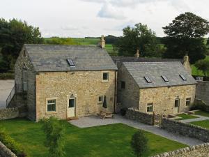 - une vue aérienne sur une maison en pierre avec une cour dans l'établissement Shippon Cottage - Brosterfield Farm, à Eyam
