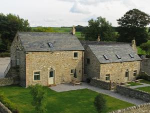 an aerial view of a stone house with a courtyard at Shippon Cottage - Brosterfield Farm in Eyam