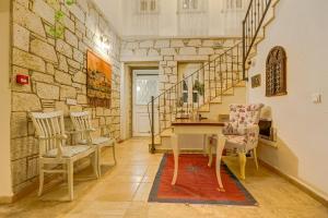 Habitación con mesa, sillas y pared de piedra. en AlaNarin Konak en Alacati